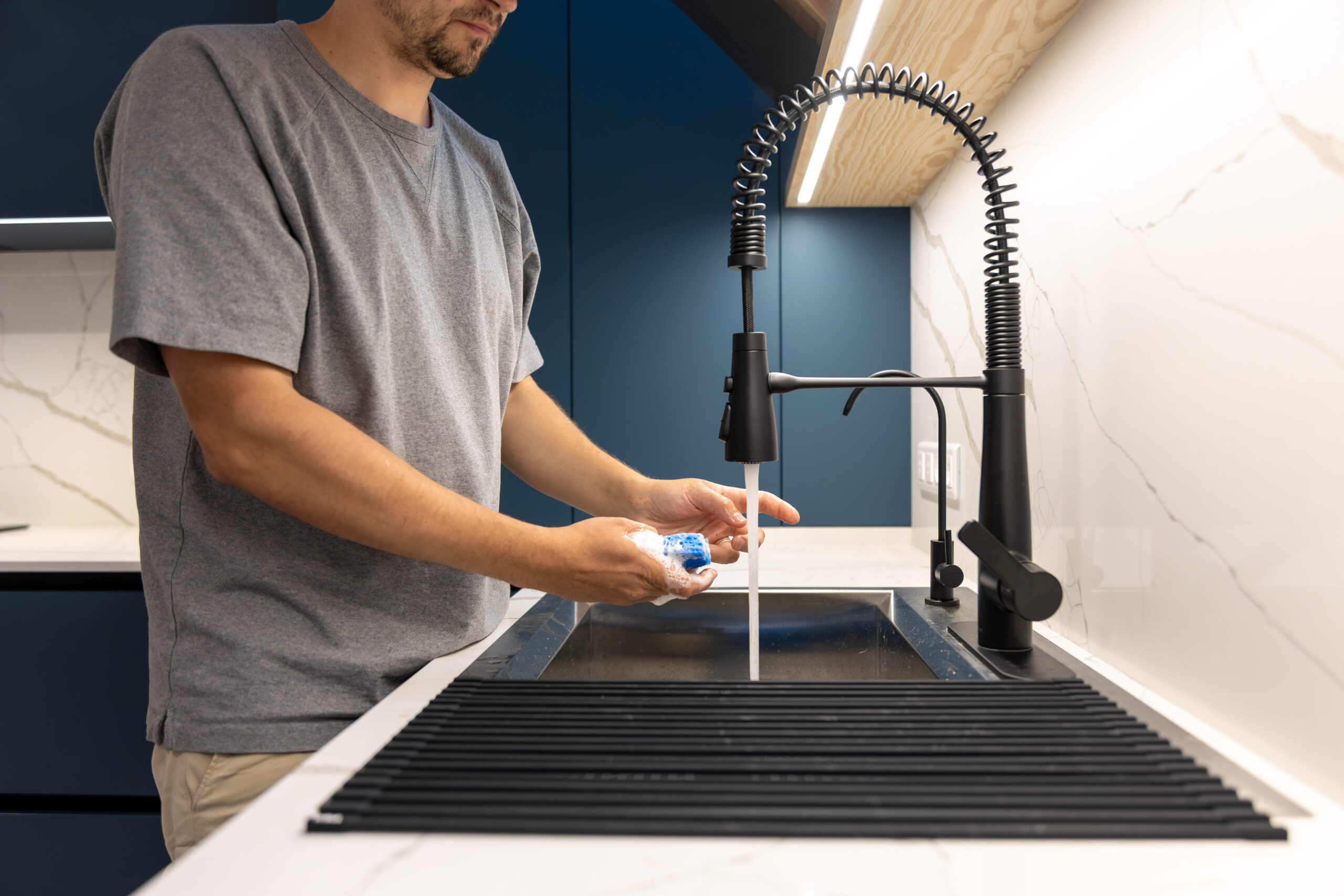 man-rinsing-dish-sponge-running-water-daily-home-hygiene (1)